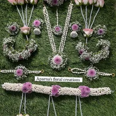 Here is a full baby shower jewellery set, laid out to show every detail. It includes a long necklace, choker, maang tikka, earrings, haath phool, and a kamarband (waistband), all made from fresh pink roses, purple flowers, and fragrant jasmine buds.