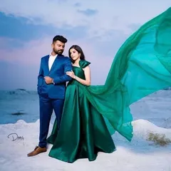 A striking look for a pre-wedding shoot. The groom's classic blue suit provides a perfect contrast to the bride's magnificent emerald green gown, creating a rich and vibrant visual.