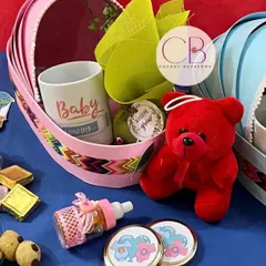 Making every occasion exciting and memorable with our baby shower hampers in cradle baskets. This one includes a "Baby" mug, a teddy bear, and other cute goodies for the mom-to-be.
