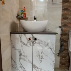 A compact bathroom vanity with a marble-finish laminate and a stylish vessel sink, a simple upgrade for any bathroom.