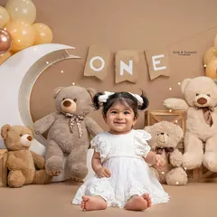 Look at that happy face! Before the smashing began, we captured this sweet portrait of the birthday girl in her beautiful white dress, surrounded by her teddy bear friends.