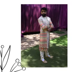 We've got ethnic elegance. This client is wearing a unique off-white sherwani with colorful chevron embroidery, a perfect blend of tradition and modern design.