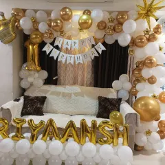 A grand living room decoration for a first birthday. I framed the sofa with a white and gold balloon arch and added the name in foil letters at the bottom, transforming the space for the celebration.