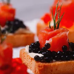 An elegant canapé of smoked salmon rosette and fine black caviar on a crisp toast point. This bite-sized appetizer showcases our flair for gourmet presentation and the use of premium ingredients, perfect for a luxury high tea or cocktail party.