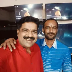A selfie with my friend Kyathaghatta Satish at his Golden TV shop. You can see my promotion video playing on the TVs in the background.