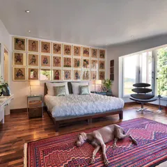 In the Aishbagh holiday home, a bedroom becomes a personal sanctuary with a view of Damdama Lake. We believe in spaces that connect with their surroundings, using natural light, art like these Kalighat paintings, and rich textiles like the Kurdish kilim to create a sense of place and peaceful retreat.
