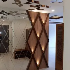 A striking accent wall with diamond-shaped wooden panels and integrated spotlights. This design, paired with a mirrored wall, creates a visually dynamic and luxurious entryway.