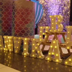 Personalized marquee letters add a special touch to any birthday setup. Here, the name 'ANVIKA' is lit up, adding warmth and a custom feel to the mermaid party decor.