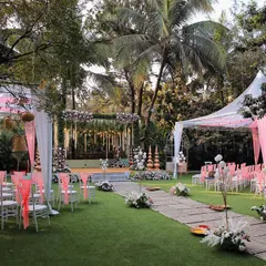 The lawn at Farmhouse Collective is a blank canvas for your event. Here, it's set up for an elegant ceremony with pink and white decor, showcasing the spacious seating arrangement under canopy tents.
