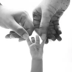 A tiny hand grasping a parent's finger, captured in beautiful black and white. This simple, powerful image tells a story of trust and love.