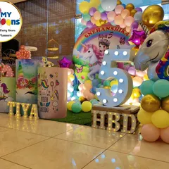 A colorful unicorn-themed fifth birthday. The setup includes a rainbow backdrop, a large unicorn foil balloon, and a 'TIYA' marquee.