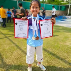 I am so proud of my students and their incredible performances. This young champion is holding her certificates and medals, a wonderful symbol of her achievement in the sport.