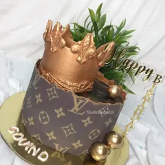 An LV themed crown cake for a stylish celebration. This ganache cake features the iconic LV print and a stunning edible gold crown on top.