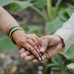 A candid shot of a couple holding hands, showcasing the beautiful, dark stain of the bride's mehendi. This is what I call stain goals.