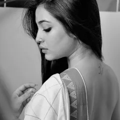 A sensual and artistic back portrait in black and white. The focus on the lines of the back and the drape of the saree creates a subtle and elegant image.