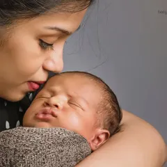 The quiet connection between a mother and her newborn is truly special. This close-up shot captures a tender kiss, highlighting the peacefulness and deep love of these first few days together.