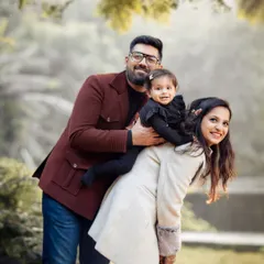 This playful family portrait in a park shows a happy, natural interaction. We encourage families to have fun during our outdoor shoots to capture genuine smiles and laughter.