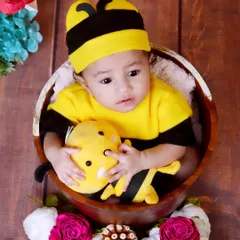 Here is another shot of our sweet little bee, looking so curious and cute. I use soft, safe props like this wooden bowl and plush toy to keep the baby comfortable and engaged during the shoot.