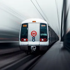 A long-exposure shot of the Delhi Metro, creating a sense of speed and motion. This image captures the lifeline of the city, a symbol of its constant movement and energy.