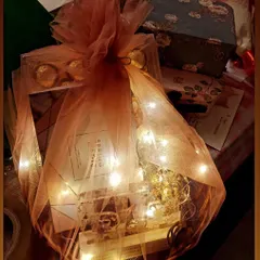 A beautifully wrapped custom gift hamper for Valentine's Day, complete with fairy lights for a magical touch.
