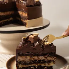 You don't have to be hungry to enjoy this. My Snickers-inspired cake has layers of chocolate sponge, nougat-like cream, and gooey caramel, all covered in a rich chocolate ganache.