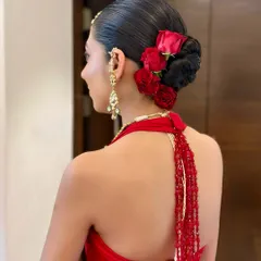 A classic and bold bridal bun adorned with fresh red roses. This hairstyle is timeless, elegant, and perfect for a traditional wedding look.