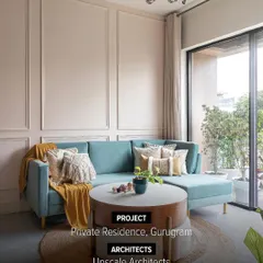 This living room in a private Gurugram residence balances comfort with quiet elegance. We used soft, neutral wainscoting and a calming color palette to create a timeless space, punctuated by a pop of color from the teal sofa for a modern, personalized feel.