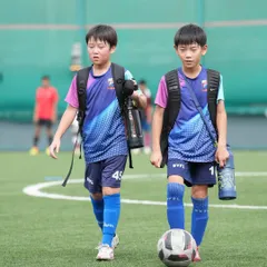 Friends forever, on and off the field. Two teammates walk together after a training session, showcasing the strong bonds that develop between our players.