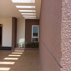 This angle shows how the patterns of light from the skylights fall across the textured exterior wall. This intentional design creates a living surface that changes throughout the day, demonstrating how architecture can be a canvas for natural light.