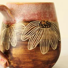 A close-up of the hand-carved floral details on my Pink Sienna mug. I use a technique called sgraffito to etch the design, revealing the natural clay color underneath the rich glaze.