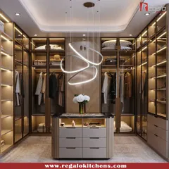 This walk-in closet is defined by its modern aesthetic, featuring a unique swirling light fixture over a functional central island. Glass doors and warm interior lighting keep the space feeling open and inviting.