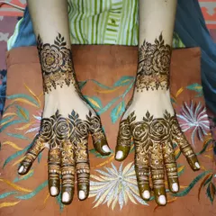 A beautiful anniversary henna design featuring elegant rose patterns on the hands and wrists.