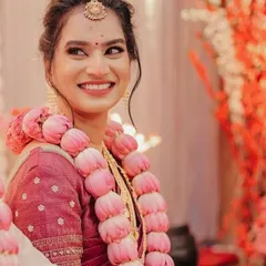 A beautiful, happy South Indian bride. Her makeup is minimal and fresh, letting her joyful smile and the traditional gold jewellery be the focus.