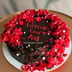 A fun and witchy cake for a friend's birthday with the message "Witches Don't Age." This dark chocolate truffle cake has a bold red and black design.