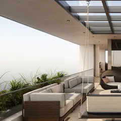 The terrace offers multiple seating zones, including a large sectional sofa and a hanging swing, perfect for everything from large gatherings to quiet moments alone. A glass railing ensures unobstructed views of the surroundings.