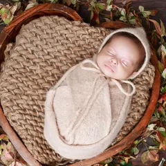The second twin from the same session, swaddled in a complementary cream color. Coordinating colors and props create a cohesive look for twin photoshoots.