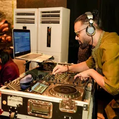 In the zone during a Dandiya night, mixing traditional Garba tracks with Bollywood beats. You can see my complete DJ setup with my laptop and mixer, ready for a long night of music.