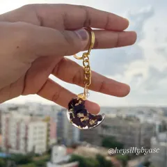 This moon-shaped keychain holds preserved rose petals and gold flakes. It's a beautiful way to carry a small piece of a special bouquet or a single meaningful flower with you wherever you go.