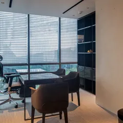The director’s cabin in this Gurugram office is a study in bespoke detail. We custom-designed the furniture, pairing a rich wood table with plush chairs to create a workspace that feels timeless and tactile. The darker palette contrasts with the room's natural light, achieving a perfect balance.