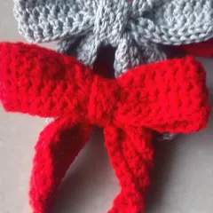 How cute are these crochet bow hair clips? This picture shows a classic red bow and a simple grey one, perfect for adding a sweet touch to any hairstyle.
