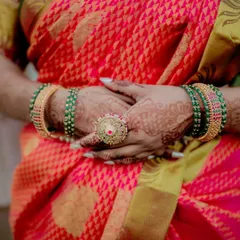 A close-up of the bride's hands, showcasing her intricate henna, colorful bangles, and a statement ring. These details are an essential part of the Indian bridal look.