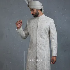 Taking cues from the arches and domes of Mughal architecture, this ivory sherwani is a masterpiece of detailed embroidery. The precise tailoring ensures a silhouette that is both regal and comfortable for your wedding day.