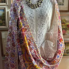 We celebrate a vibrant fusion of crafts with this ensemble. A pristine white Chikankari suit, detailed with delicate mirrorwork, is paired with a colorful Kashmiri Kalamkari dupatta, showcasing a symphony of floral and paisley motifs.