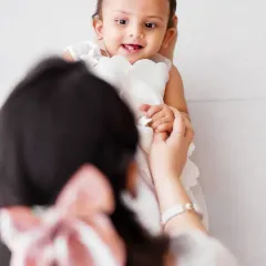 An over the shoulder shot focusing on the baby's sweet expression. This angle provides a unique and intimate perspective, capturing the connection from the mother's point of view.