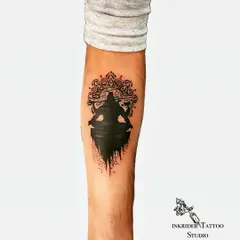 We concealed an old initial tattoo and surrounding scars with this powerful Mahadev silhouette. The design uses solid black ink and a detailed mandala background to create a bold statement piece on the forearm, completely hiding the previous ink.
