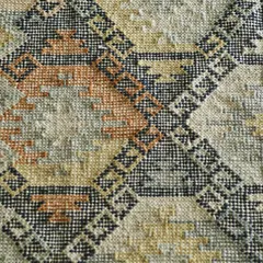 A close-up of a handwoven dhurrie, showing the intricate geometric pattern and the rich, earthy color palette. These are the handwoven stories under your feet that define both comfort and style.