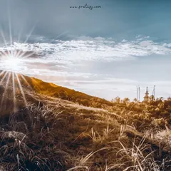A sunburst over the hills of Singalila National Park, captured in infrared. The grass and foliage take on a golden hue, contrasting sharply with the deep blue sky.