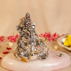 Here, Lord Ganesha is presented on a beautiful rose quartz base, a stone known for its calming energy. The silver-plated idol is intricately detailed with red and gold accents, creating a piece that is both spiritually significant and aesthetically pleasing.