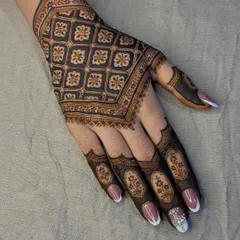 A beautiful example of 'jaal' or grid-based design. The repeating floral pattern creates a stunning, cloth-like effect on the back of the hand.