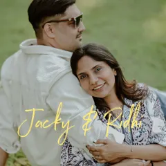 A relaxed and stylish pre-wedding portrait. The couple's comfortable pose and the clean, simple background create a modern and effortlessly chic image.